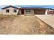 Tan single-story home featuring a red door, two-car garage, and solar panels on the roof at 3702 E Karen Dr, Phoenix, AZ 85032