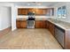 Modern kitchen with granite countertops, stainless steel appliances, and wood-finished cabinets at 3702 E Karen Dr, Phoenix, AZ 85032