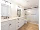 Modern bathroom featuring double sinks, white cabinets, large mirror, and a walk-in shower at 4038 E Wescott Dr, Phoenix, AZ 85050