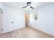 This bedroom includes wood grain flooring, white trim, window, and a white door at 4038 E Wescott Dr, Phoenix, AZ 85050