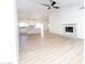 Bright living room featuring new floors, fireplace, modern fan, and open to the updated kitchen at 4038 E Wescott Dr, Phoenix, AZ 85050