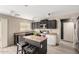 Open kitchen featuring black cabinetry, stainless steel appliances, an island with barstool seating at 43724 W Cowpath Rd, Maricopa, AZ 85138