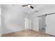 Bedroom featuring wood floors, barn door, and ensuite bath entrance at 4383 N 203Rd Dr, Buckeye, AZ 85396