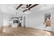 Open-concept living room boasts wood beam ceilings and adjoins modern kitchen with island at 4383 N 203Rd Dr, Buckeye, AZ 85396