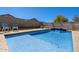 Cool blue swimming pool with waterfall feature and comfortable lounge chairs at 4407 E Meadow West Ln, Queen Creek, AZ 85140