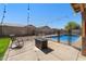 Backyard featuring a fenced pool with a seating area and desert landscaping at 4407 E Meadow West Ln, Queen Creek, AZ 85140