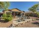 Well-maintained backyard featuring a covered patio, a dining set, built-in fire pit, and desert landscaping at 4415 W Ellis St, Laveen, AZ 85339