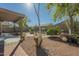 Inviting backyard with a covered patio, mature landscaping, seating, and a cozy fire pit area at 4415 W Ellis St, Laveen, AZ 85339