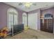Bright bedroom with mauve walls, neutral carpet, closet, plantation shutters, and ceiling fan at 4415 W Ellis St, Laveen, AZ 85339