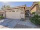 Close-up of the garage door and front entrance with a security gate and desert-style landscaping at 4415 W Ellis St, Laveen, AZ 85339