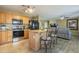 Eat-in kitchen featuring a granite island with bar seating, black appliances, and open floor plan at 4415 W Ellis St, Laveen, AZ 85339