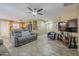 Open-concept living room with tile floors flowing into the kitchen area, featuring gray couches at 4415 W Ellis St, Laveen, AZ 85339