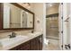 Bathroom boasts a dual sink vanity with dark wood cabinetry and a glass-enclosed shower at 5641 E Grovers Ave, Scottsdale, AZ 85254