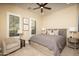 Bright bedroom with a ceiling fan, shutters, and an ensuite bathroom at 5641 E Grovers Ave, Scottsdale, AZ 85254