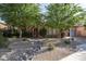 Inviting home exterior with mature trees, well-maintained landscaping, and a stone-lined dry creek bed at 5641 E Grovers Ave, Scottsdale, AZ 85254