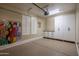 Organized garage featuring epoxy floor, storage cabinets, and stylish decor, maximizing space at 5641 E Grovers Ave, Scottsdale, AZ 85254