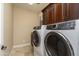 Bright laundry room featuring modern washer and dryer, and rich wood cabinetry at 5641 E Grovers Ave, Scottsdale, AZ 85254