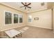 Spacious living room featuring plantation shutters, and a modern ceiling fan at 5641 E Grovers Ave, Scottsdale, AZ 85254
