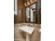 Elegant powder room featuring a pedestal sink, decorative tile, and stylish fixtures at 5641 E Grovers Ave, Scottsdale, AZ 85254
