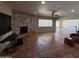 Spacious living room featuring a stone fireplace, tile flooring, and large windows that flood the space with natural light at 5829 E Windsor Ave, Scottsdale, AZ 85257