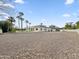 Exterior view showing spacious gravel area, desert landscaping, and mature palm trees at 6129 E Turquoise Ave, Paradise Valley, AZ 85253