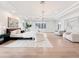 Spacious main bedroom featuring light wood floors, white walls, sitting area, and tray ceiling at 6129 E Turquoise Ave, Paradise Valley, AZ 85253