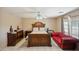 Spacious main bedroom featuring an elegant wood bed frame and a vibrant red sofa, blending style and comfort at 7329 W Lamar Rd, Glendale, AZ 85303