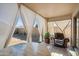Relaxing covered patio area with a chair and white curtain panels for privacy and comfort at 7329 W Lamar Rd, Glendale, AZ 85303