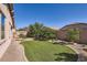 Lush backyard with artificial turf, a low-maintenance xeriscape, and mature trees creating a private retreat at 7589 W Quail Track Dr, Peoria, AZ 85383