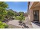 Beautifully landscaped backyard with lush green lawn, brick-paved patio, and mature citrus trees at 7589 W Quail Track Dr, Peoria, AZ 85383