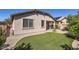 Charming backyard with low-maintenance artificial turf, mature trees, and covered patio at 7589 W Quail Track Dr, Peoria, AZ 85383