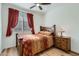 Cozy bedroom with a wood bed frame, plush bedding, and a side table with a lamp at 7589 W Quail Track Dr, Peoria, AZ 85383