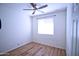 Cozy bedroom with wood-look laminate flooring, ceiling fan, and a bright window at 7589 W Quail Track Dr, Peoria, AZ 85383