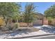 Front exterior with desert landscaping, mature trees, and a two-car garage at 7589 W Quail Track Dr, Peoria, AZ 85383