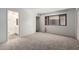 Bedroom featuring neutral carpet, a window for natural light, and an adjacent bathroom for convenience at 7843 E Valley View Rd, Scottsdale, AZ 85250