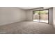 Cozy carpeted bedroom featuring natural light and access to the backyard through a sliding glass door at 7843 E Valley View Rd, Scottsdale, AZ 85250