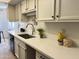 Bright kitchen featuring quartz countertops, stainless steel sink, and white cabinetry at 7843 E Valley View Rd, Scottsdale, AZ 85250