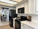 This kitchen features black appliances, white cabinets and quartz countertops at 7843 E Valley View Rd, Scottsdale, AZ 85250