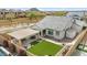 Aerial view of home and yard with outdoor kitchen, artificial grass lawn, and desert landscaping at 8154 E Jaeger St, Mesa, AZ 85207