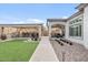 Beautiful backyard with covered outdoor kitchen, lush turf, and stone pathway to home at 8154 E Jaeger St, Mesa, AZ 85207