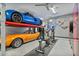 Spacious garage with car lift, exercise equipment, epoxy flooring, and car-themed decor at 8154 E Jaeger St, Mesa, AZ 85207