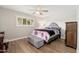 Inviting bedroom featuring a decorative ceiling fan, soft natural light, and hardwood flooring at 8656 E Plaza Ave, Scottsdale, AZ 85250