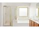 Bright white bathroom features a soaking tub under a window and separate shower at 10001 W Potter Dr, Peoria, AZ 85382