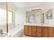 Bright bathroom with double sink vanity, framed mirrors, and tub with shower, complemented by natural light from window at 10001 W Potter Dr, Peoria, AZ 85382