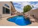 Sparkling pool with rock waterfall feature surrounded by a concrete patio and lush landscaping at 10001 W Potter Dr, Peoria, AZ 85382