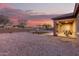 A low-maintenance backyard features a stone landscape, a small grass plot, and covered patio area, perfect for outdoor living at 19011 E Carriage Way, Queen Creek, AZ 85142