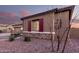 This home features charming desert landscaping, a rock facade, and striking red shutters and trim at 19011 E Carriage Way, Queen Creek, AZ 85142
