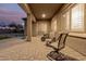 An inviting covered patio features brick flooring and comfortable seating, perfect for enjoying the outdoors at 19011 E Carriage Way, Queen Creek, AZ 85142