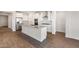 Bright, open kitchen featuring white cabinets, stainless steel appliances, and wood-look flooring at 21277 N 272Nd Ave, Buckeye, AZ 85396