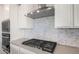 Close-up of a kitchen range with stainless steel hood and decorative backsplash at 21277 N 272Nd Ave, Buckeye, AZ 85396